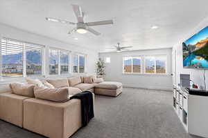 Carpeted living room with ceiling fan, a textured ceiling, and recessed lighting