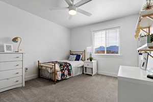 Bedroom with light carpet, a textured ceiling, and a ceiling fan