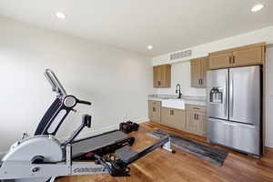 Exercise room featuring light wood-type flooring and recessed lighting