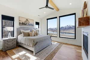 Bedroom with a ceiling fan, recessed lighting, light wood-type flooring, beamed ceiling, and a water and mountain view