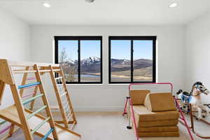 Bedroom featuring a mountain view, multiple windows, light carpet, and recessed lighting