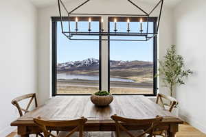 Dining room with wood finished floors, a water and mountain view, and plenty of natural light