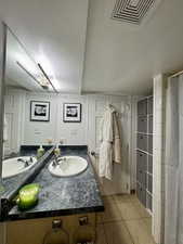Full bathroom featuring vanity, a shower with curtain, and light tile patterned floors
