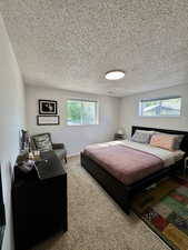Bedroom with light carpet and a textured ceiling