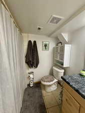 Bathroom featuring a shower with curtain, vanity, and light tile patterned floors