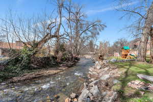 View of yard with a playground and a water view