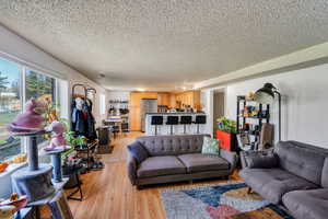 Living room with a textured ceiling and light wood-style flooring