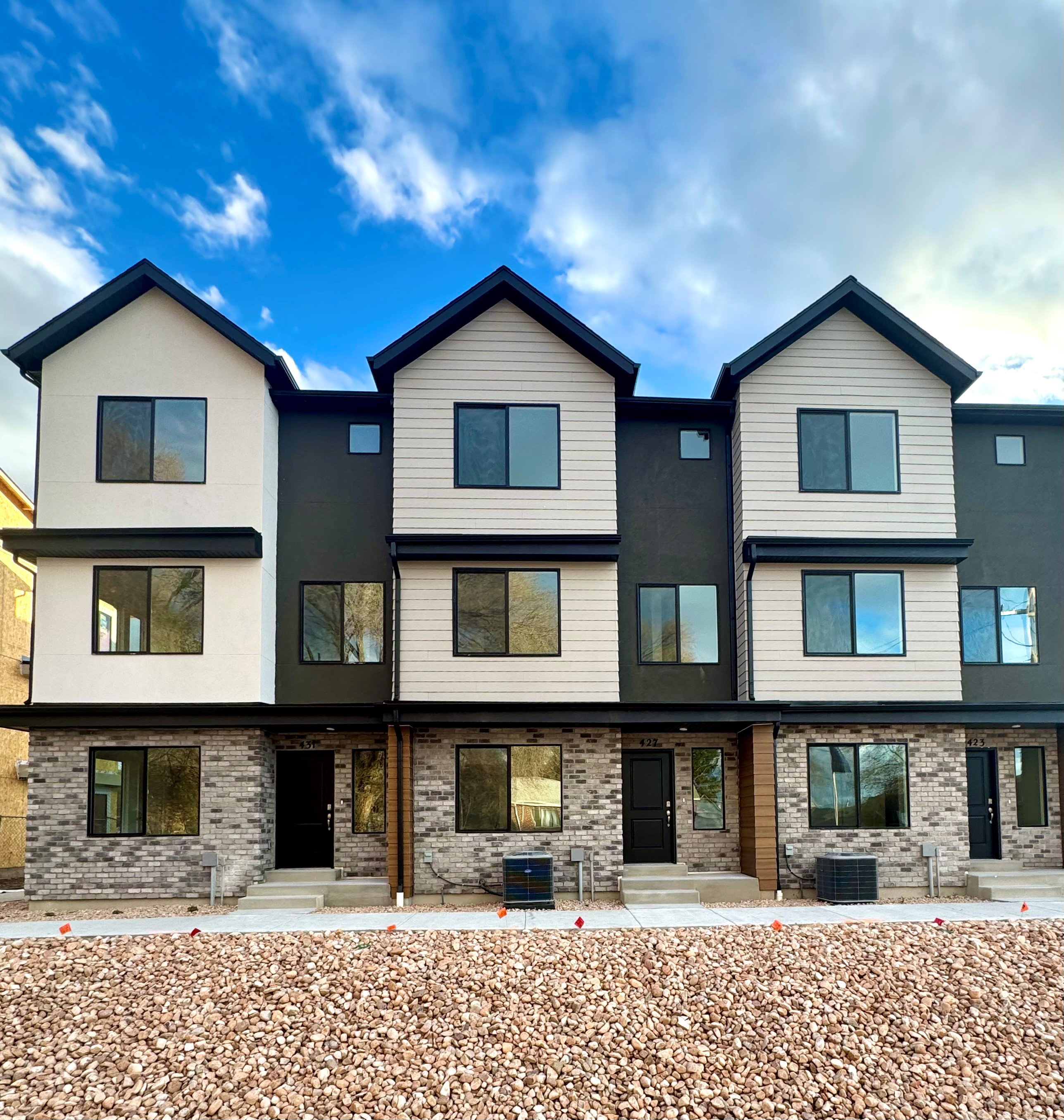 Contemporary house featuring entry steps, brick siding, and stucco siding