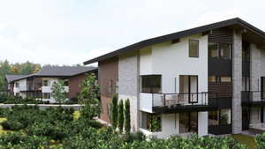 Back of house featuring a balcony and stucco siding