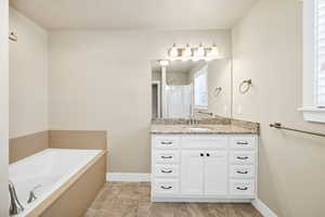 Bathroom featuring vanity, a bath, and a stall shower