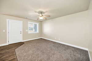 Unfurnished room with a ceiling fan and dark wood-style floors
