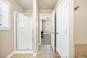 Full bathroom featuring a stall shower and baseboards