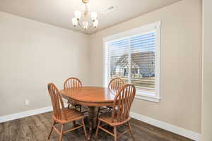 Dining space with suspended lighting and dark wood finished floors
