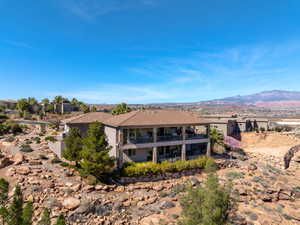 Rear view of house featuring stucco siding, a mountain view, and a balcony