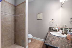 Full bathroom with vanity, a tile shower, and light tile patterned flooring