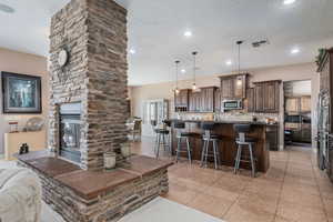 Living area featuring light tile patterned floors, a fireplace, recessed lighting, and a textured ceiling