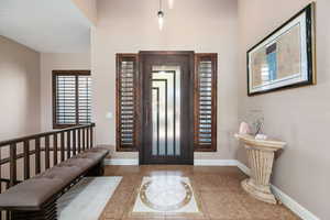 Foyer entrance featuring inlaid floor details and baseboards