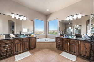 Bathroom with two vanities, a garden tub, and a stall shower