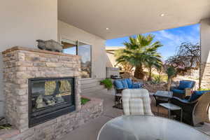 View of patio featuring an outdoor stone fireplace and an outdoor living / dining area