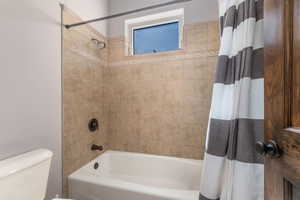 Full bathroom with shower / tub combo and toilet