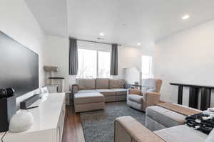Living area featuring dark wood-style floors and recessed lighting