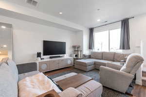Living room with dark wood finished floors and recessed lighting