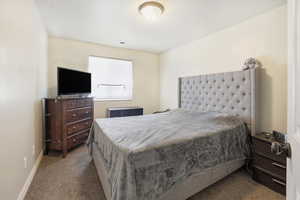 Bedroom with dark carpet and baseboards