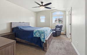 Carpeted bedroom with lofted ceiling and a ceiling fan