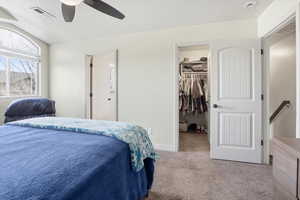 Bedroom featuring a spacious closet, carpet floors, ceiling fan, and lofted ceiling
