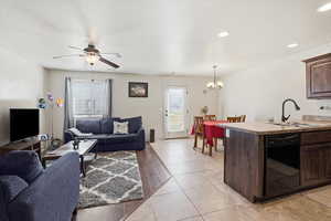 Living area featuring ceiling fan, light tile patterned flooring, suspended lighting, and a textured ceiling