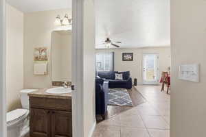 Half bath featuring vanity, light tile patterned floors, and ceiling fan