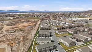 Aerial view of property and surrounding area with nearby suburban area and a mountainous background