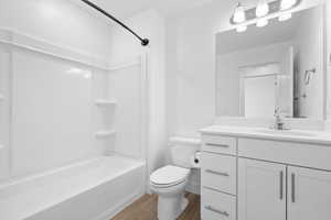 Bathroom featuring vanity, washtub / shower combination, and light wood-style flooring