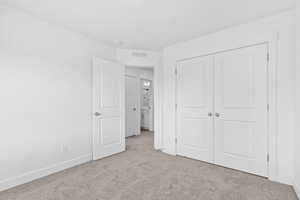 Unfurnished bedroom with carpet and a closet