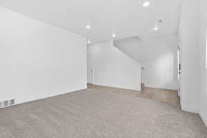 Unfurnished living room featuring light carpet and recessed lighting