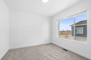 Empty room featuring baseboards and light carpet