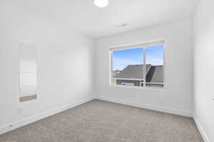 Empty room featuring carpet and baseboards