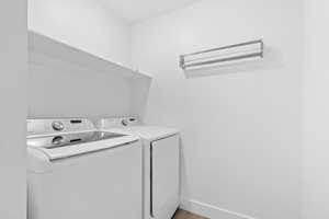 Laundry area featuring washer and clothes dryer and light wood-style floors