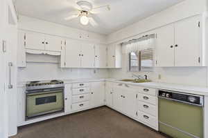 Kitchen featuring range with electric stovetop, light countertops, white cabinetry, and ceiling fan