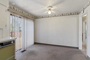 Unfurnished room with light carpet, a ceiling fan, and a textured ceiling