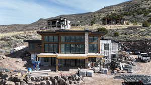 Rear view of property with a mountain view and a patio