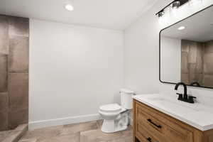 Full bathroom featuring vanity, recessed lighting, and tiled shower
