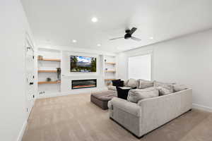 Living area featuring a custom-built entertainment center, high-end electric fireplace, high end carpet, recessed lighting. Also there is a large fully finished storage closet just off of this room.