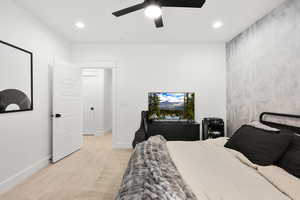Bedroom featuring light carpet, recessed lighting, a ceiling fan, and an accent wall