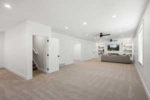 Living area featuring recessed lighting, built in features, light colored carpet, and a ceiling fan