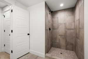 Full bathroom featuring a stall shower, recessed lighting, and light tile patterned floors