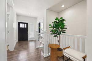 Entrance foyer with dark wood-type flooring and recessed lighting