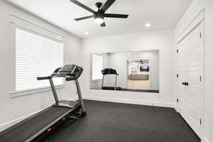 Workout room with a ceiling fan and rubberized gym flooring!  This room could be an extra bedroom, as it has a full egress window and full closet!