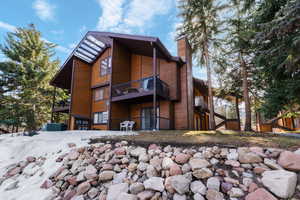Rear view of house featuring a chimney and a deck