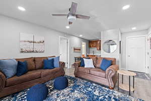 Living area with light wood finished floors, ceiling fan, and recessed lighting
